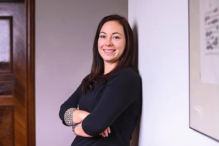 Porträt von Ruth Jana Braunsteffer vor einer Wand.